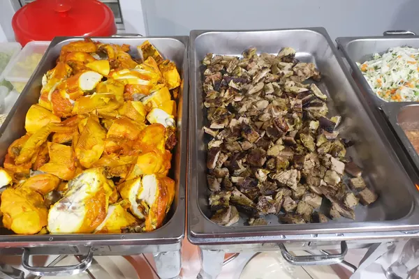 Ayam dan daging bakar dalam bekas bufet berasingan, salad di sebelah