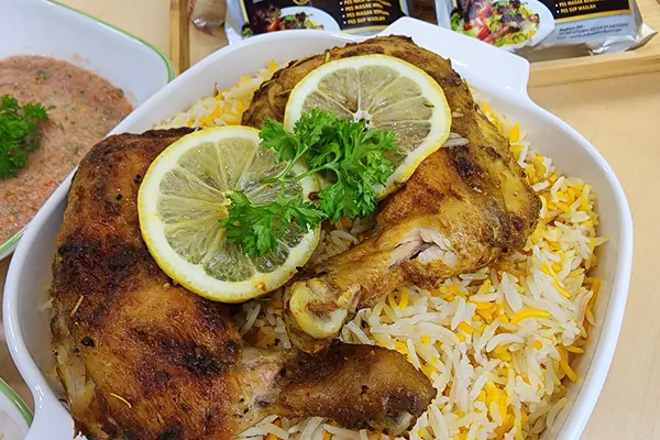 Lauk nasi arab: nasi Yemeni Mendhi dengan ayam bakar di atas daun salad, mangkuk sos tomato dan salatah