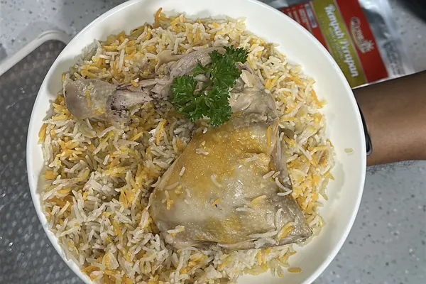 Nasi Yemeni Mendhi dengan suku ayam yang dimasak sekali dalam periuk nasi, dihias daun parsley