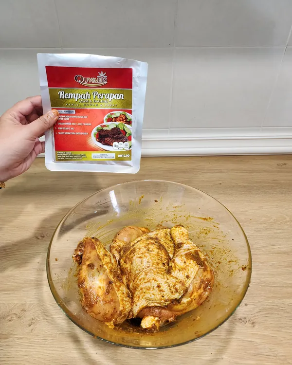 Pek Rempah Perapan Ayam dan Daging dipegang di atas mangkuk ayam yang sudah digaul dengan rempah